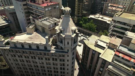 Aerial-orbit-of-the-Ariztía-Building---first-skyscraper-in-Santiago-Chile-on-a-sunny-day---La-Bolsa-Neighborhood
