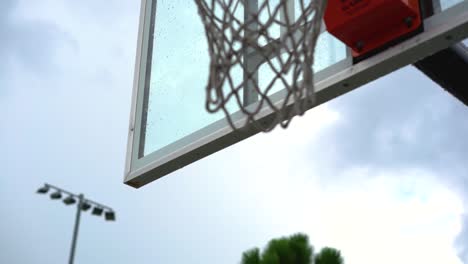 Dripping-wet-basketball-backboard-after-heavy-rainfall-on-city-playground