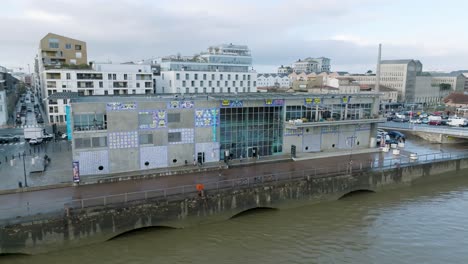 CAP-Sciences-children's-museum-building-in-the-shores-of-the-Garonne-River,-Aerial-pan-left-shot
