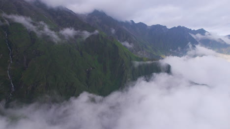 Cinematic-drone-shot-hills-covered-by-Fog-and-clouds,-waterfall-and-mountain-range-view-Nepal-4K