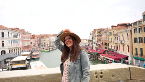Happy-woman-tourist-enjoying-the-view-from-Rialto-Bridge,-Venice