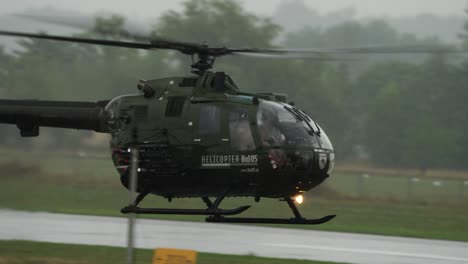 Pilot-Fliegt-Hubschrauber-MBB-BO105-In-Geringer-Höhe-über-Boden-Während-Der-Flugshow