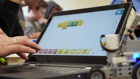 Rack-Fokus-Vom-Roboterauto-Auf-Den-Bildschirm-Eines-Laptops-In-Einem-Klassenzimmer,-In-Dem-Schüler-Lernen,-Roboter-Zu-Programmieren