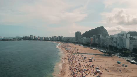 Drohne-Fliegt-über-Vielen-Menschen,-Die-Den-Strand-In-Rio-De-Janeiro-Genießen