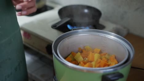 Yellow-and-orange-sweet-potato-in-green-steam-cooker,-filmed-as-medium-closeup-slow-motion-shot