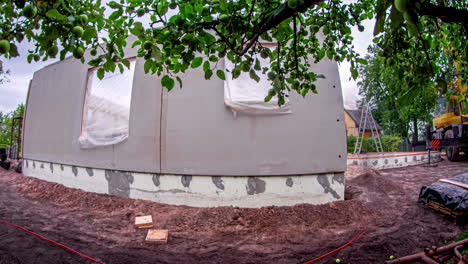 Time-lapse-of-wall-construction-of-a-detached-house,-on-a-cloudy-summer-day