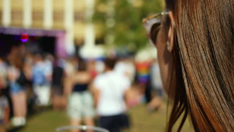 Pretty-brunette-woman-drinking-red-wine-at-outdoor-music-festival