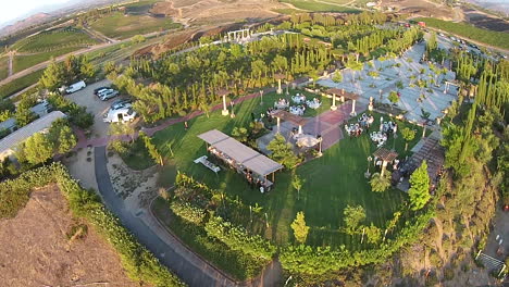 Aerial-drone-flyover-of-winery-wedding-reception,-vineyard-and-a-wedding-area-with-no-people