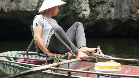 El-Hombre-Tradicional-Vietnamita-Rema-El-Barco-Usando-Sus-Pies-En-El-Sitio-De-La-Unesco-De-Trang-An.