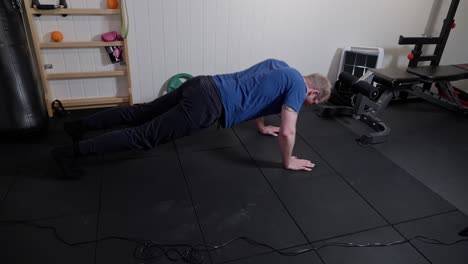 Middle-aged-man-doing-pushups-in-his-home-gym