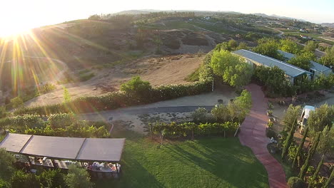 Aerial-drone-flyover-of-winery-during-wedding-with-lens-flare
