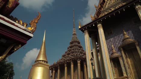 Tilting-Upshot,-Tourists-Gathering-and-Takes-a-photo-of-Emerald-Buddha-Temple,-Scenic-view-of-Golden-Pagoda-in-the-background