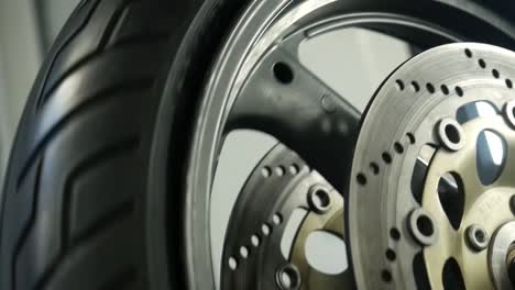 View-Of-Spinning-Motorbike-Tyre-With-Disc-Brake-Inside-Workshop