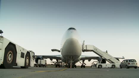 Ground-level-view-of-a-cargo-plane-with-loading-equipment-at-dawn-on-an-airport-tarmac