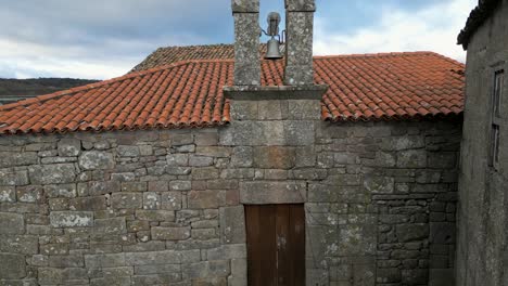 Iglesia-De-Santa-Eufemia-De-Ambia-Con-Antigua-Puerta-De-Madera-Y-Tradicional-Pared-De-Roca-Apilada