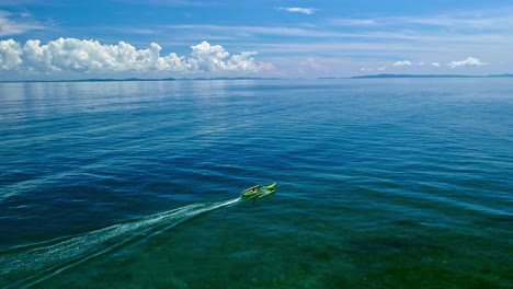 Banka-boat-fishing-in-turquoise-sea-water-off-Dinagat-Island,-Philippines