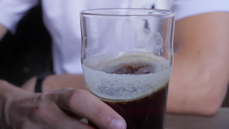 El-Hombre-Mueve-Una-Pinta-De-Cerveza-Oscura,-Cámara-Lenta.