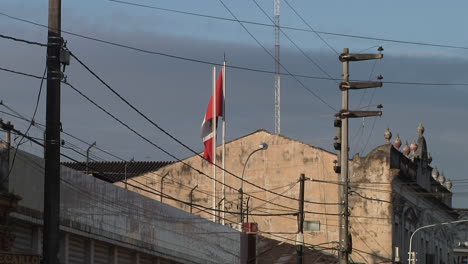 Peruanische-Flagge-Auf-Dem-Dach-Eines-Gebäudes,-Die-Im-Wind-Weht