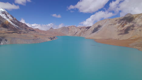 Blue-Lake-Tilicho-Nepal-drone-shot,-World's-Highest-Altitude-Lake-Annapurna-Mountain-Circuit,-sunny-weather-landscape,-country-asset-4K