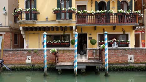 Weibliche-Touristenspaziergänge-Zwischen-Anlegestelle-Und-Gelbem-Gebäude-In-Venedig