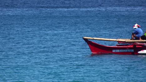 Closeup-shot-of-fishermen-on-a-red-boat-fishing-on-the-ocean