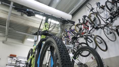 Low-Angle-View-Of-Mountain-Bike-Inside-Workshop-With-Other-Bikes-On-Wall