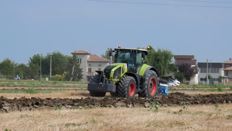 Tractor-ploughing-the-terrain-moving-from-screen-right-to-left