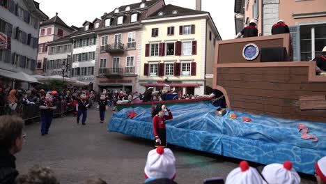 Solothurn,-Switzerland---March-03th,-2019:-A-carnivals-club-with-funny-masks-looking-like-Pop-Eye-on-their-huge-vehicle