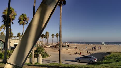 Escultura-De-Declaración-En-La-Playa-De-Venecia,-Alto,-Brazos-De-Acero-Alcanzando-El-Cielo,-Tarde-Soleada,-En-Los-Angeles,-California,-Estados-Unidos---Toma-Panorámica,-Inclinación-Hacia-Arriba