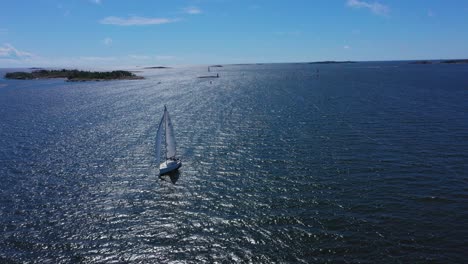 Drone-shot-around-a-white-sail-boat,-sailing-on-the-high-seas,-on-the-Baltic-ocean,-bright,-sunny,-summer-day,-in-Uusimaa,-Finland---circling,-aerial-view