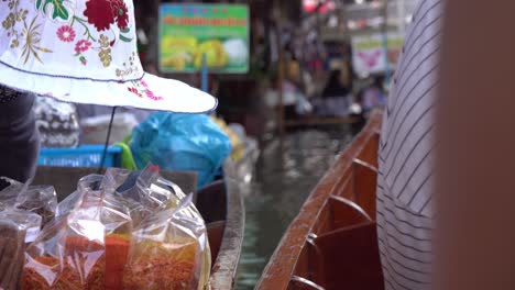 Nahaufnahme-Von-Vnedor-Hand-Und-Produkten-Im-Boot-Auf-Dem-Schwimmenden-Markt,-Bangkok,-Thailand
