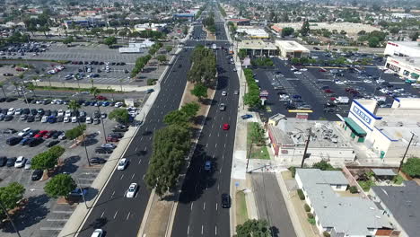 Slow-motion-aerial-drone-flying-North-over-Hawthorne-Blvd-traffic,-homes-and-businesses