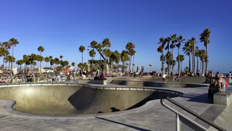 People-skating-at-the-Venice-Beach-Skate-Park,-on-a-sunny-day,-in-Los-Angeles,-California,-USA---Static-handheld-shot