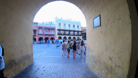 Turistas-Con-Mochilas-Caminan-En-Una-Plaza-Del-Casco-Antiguo-De-Cartagena-De-Indias,-Colombia