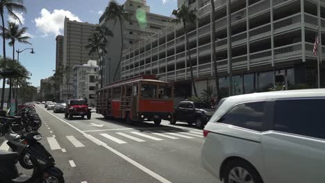 Waikiki-Trolley-Touristenbus-überquert-Den-Ala-Wai-Boulevard-In-Oahu,-Hawaii-–-Kamerafahrt-Mit-Weitwinkelschwenk