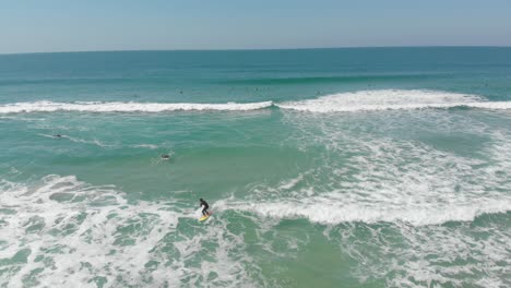 Coastal-life,-surfer-learning-to-cruise-on-the-foamy-mild-waves-of-Santinho-beach-Florianópolis-city-Brazil