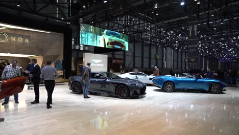 Geneva,-Switzerland---March-12th,-2019:-high-angle-wide-panning-shot-of-the-Aston-Martin-booth-at-Autosalon-Geneva-Motor-Show-2019