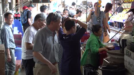 Maeklong-Railway-Market,-Thailand,-People-and-Vendors-Under-Sunshades-on-Busy-Unique-Marketplace