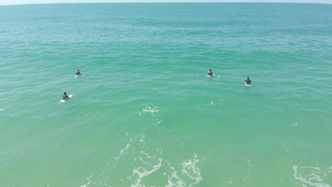 Grupo-Principiante-De-Surfistas-Esperando-Que-Se-Formen-Las-Olas,-En-La-Playa-Costera-De-Santinho-En-Brasil