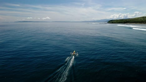 Banka-boat-fishing-off-coastline-of-Dinagat-Island,-Philippines,-drone-follow