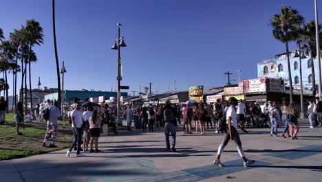 Masked-people-walking-at-the-Venice-Boardwalk-shopping,-during-golden-hour,-in-Los-Angeles,-California,-USA---Quiet-do-to-the-Coronavirus-pandemic