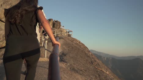 Cinematic-gimbal-shot-of-tourists-climbing-the-staircase-to-the-top-of-Moro-Rock-in-California's-Sequoia-National-Forest