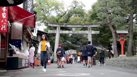 Turistas-Y-Lugareños-Caminando-Por-Las-Calles-De-Kioto,-Ante-El-Santuario-Sintoísta