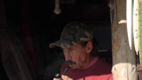 Old-fisherman-with-khaki-hat-smoking-pipe,-slow-motion