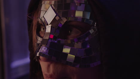 Closeup-of-mysterious-woman-wearing-reflective-glimmering-mask-and-hook
