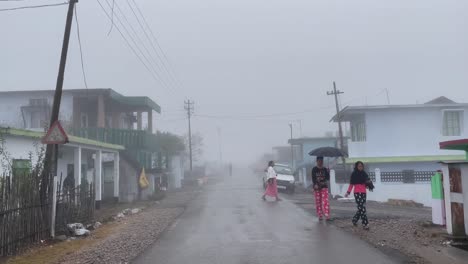 La-Gente-Del-Pueblo-Caminando-Por-La-Calle-Mojada-En-Una-Fría-Mañana-De-Niebla-En-Meghalaya,-India