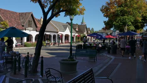 People-eating-and-walking-around-the-street-in-Solvang,-California-on-a-sunny-day