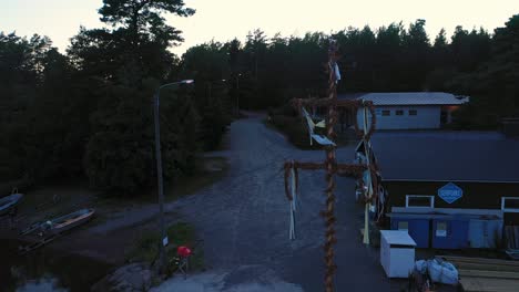 Aerial-view-around-a-traditional-midsummer-pole,-in-Sandnasudd,-Raasepori,-Uusimaa,-Finland---Orbit,-drone-shot