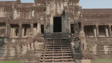 Gehen-Sie-Langsam-Auf-Einen-Großen-Eingang-In-Angkor-Wat-Zu,-Mit-Löwenstatuen-An-Der-Seite-Der-Treppe,-Während-Sie-Sich-Nach-Oben-Neigen