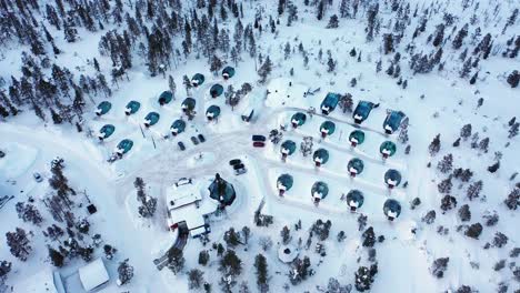 Aerial-view-of-aurora-igloos,-sunny-evening,-in-Lapland---tracking,-drone-shot